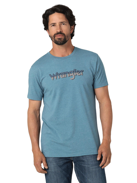 Wrangler 112336214 Mens American Flag Logo T-Shirt Medium Blue front view on model. If you need any assistance with this item or the purchase of this item please call us at five six one seven four eight eight eight zero one Monday through Saturday 10:00a.m EST to 8:00 p.m EST