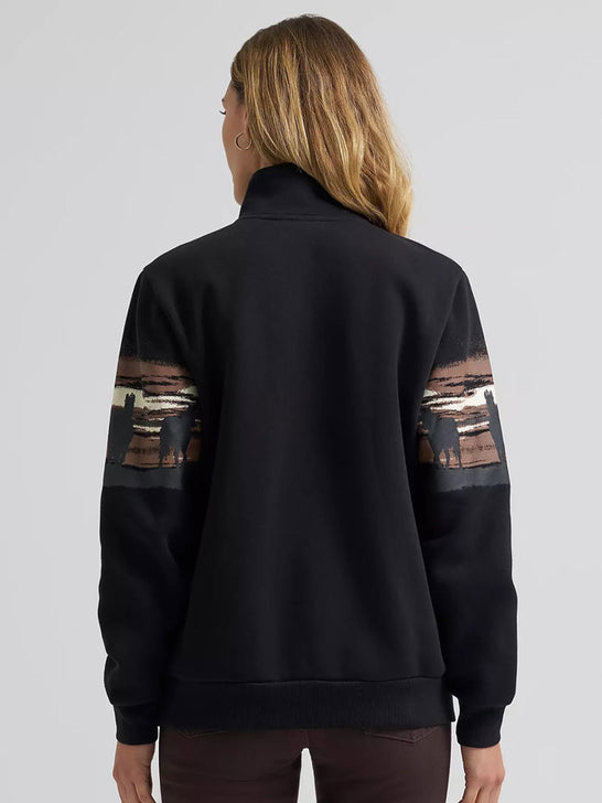 A woman viewed from the back wearing a black quarter-zip sweatshirt with brown and beige graphic panels on the upper sleeves, paired with dark brown pants, against a light gray studio background. If you need any assistance with this item or the purchase of this item please call us at five six one seven four eight eight eight zero one Monday through Saturday 10:00a.m EST to 8:00 p.m EST