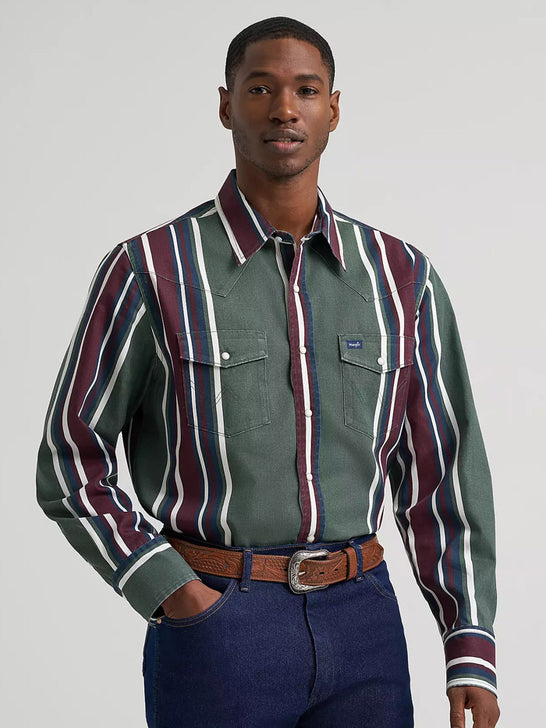 A man wearing a green western-style button-down shirt with vertical burgundy, white, and navy stripes, paired with a brown belt and dark blue jeans, against a light gray studio background. If you need any assistance with this item or the purchase of this item please call us at five six one seven four eight eight eight zero one Monday through Saturday 10:00a.m EST to 8:00 p.m EST