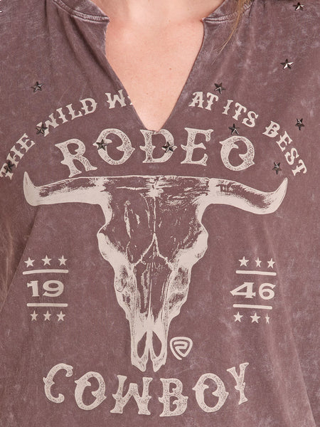 Close-up of a person wearing a distressed brown V-neck t-shirt with a western 'Rodeo Cowboy' graphic featuring a bull skull and stars. If you need any assistance with this item or the purchase of this item please call us at five six one seven four eight eight eight zero one Monday through Saturday 10:00a.m EST to 8:00 p.m EST