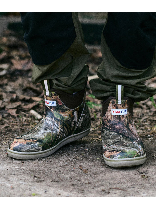 Xtratuf XMABMDNA Mens Ankle Deck Boot Mossy Oak Country DNA outdoors view. If you need any assistance with this item or the purchase of this item please call us at five six one seven four eight eight eight zero one Monday through Saturday 10:00a.m EST to 8:00 p.m EST