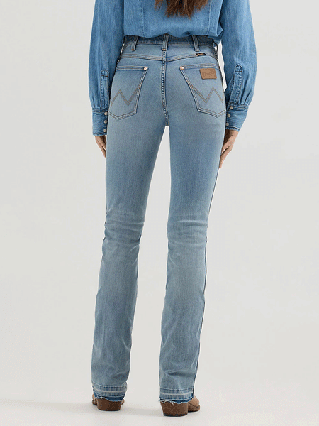 Wrangler 112360639 Womens X Lainey Wilson Raw Hem Boot Hugger Jeans Sky Wash back view. If you need any assistance with this item or the purchase of this item please call us at five six one seven four eight eight eight zero one Monday through Saturday 10:00a.m EST to 8:00 p.m EST