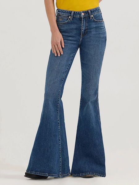 Wrangler 112360638 Womens X Lainey Wilson Bell Bottoms Jeans Baskin Blue Wash front. If you need any assistance with this item or the purchase of this item please call us at five six one seven four eight eight eight zero one Monday through Saturday 10:00a.m EST to 8:00 p.m EST