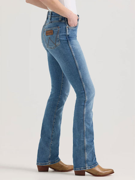 Wrangler 112344635 Womens Retro Bailey High Rise Bootcut Jean Ember Medium Blue side view. If you need any assistance with this item or the purchase of this item please call us at five six one seven four eight eight eight zero one Monday through Saturday 10:00a.m EST to 8:00 p.m EST