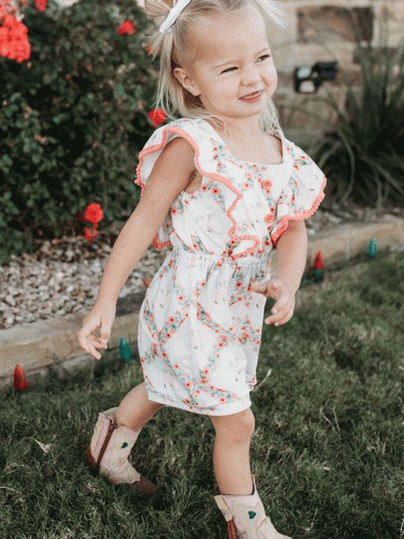 Shea Baby JUP06 Kids Floral Boot Romper White side view on model. If you need any assistance with this item or the purchase of this item please call us at five six one seven four eight eight eight zero one Monday through Saturday 10:00a.m EST to 8:00 p.m EST