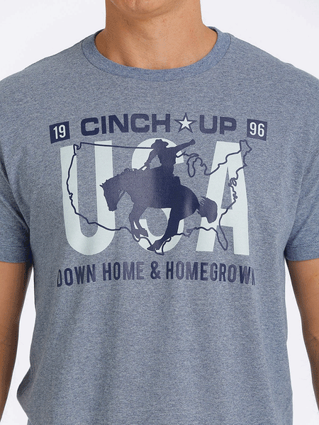 Cinch MTT1690500-HBL Mens Cinch Up Tee Denim Blue graphic detail close up. If you need any assistance with this item or the purchase of this item please call us at five six one seven four eight eight eight zero one Monday through Saturday 10:00a.m EST to 8:00 p.m EST