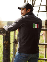 Ariat 10031424 Mens New Team Softshell Mexico Wtr Rstnt Jkt Black back view on model outdoors. If you need any assistance with this item or the purchase of this item please call us at five six one seven four eight eight eight zero one Monday through Saturday 10:00a.m EST to 8:00 p.m EST