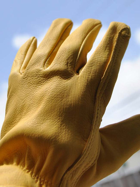 HD Xtreme Work H2110408 Mens Deer Skin Leather Gloves Tan left hand view on model. If you need any assistance with this item or the purchase of this item please call us at five six one seven four eight eight eight zero one Monday through Saturday 10:00a.m EST to 8:00 p.m EST