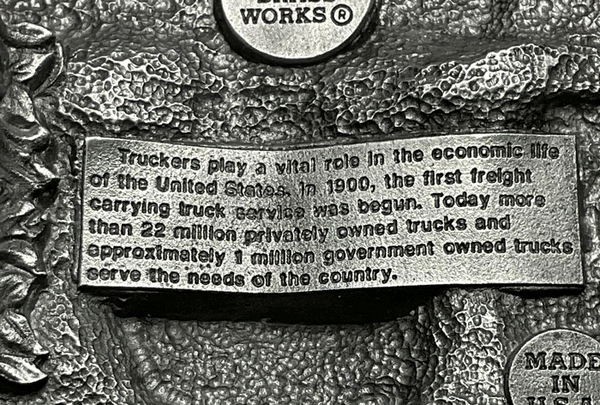 Western Express BU-007-E Proud To Be An American Trucker Belt Buckle back close up. If you need any assistance with this item or the purchase of this item please call us at five six one seven four eight eight eight zero one Monday through Saturday 10:00a.m EST to 8:00 p.m EST