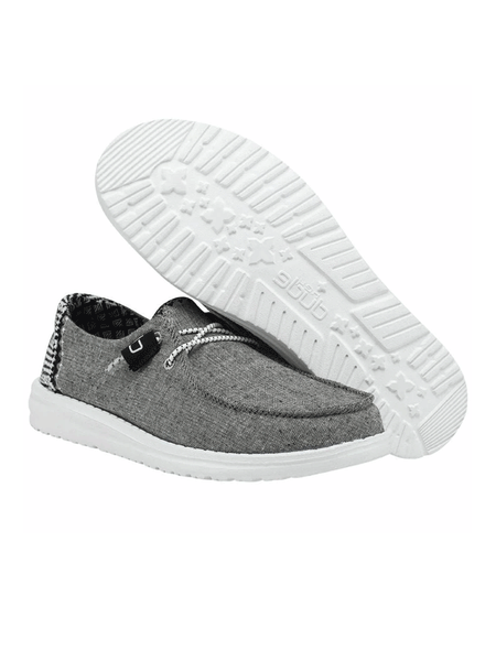 Hey Dude 130124203 Youth Wendy Shoe Chambray Onyx sole and side view. If you need any assistance with this item or the purchase of this item please call us at five six one seven four eight eight eight zero one Monday through Saturday 10:00a.m EST to 8:00 p.m EST
