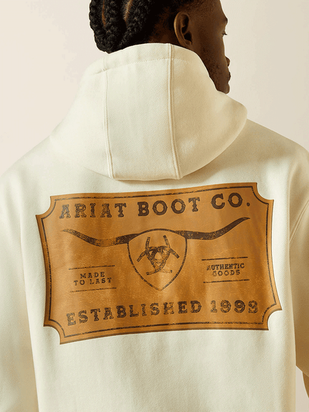 Ariat 10062499 Mens Shield Steerhead Hoodie Oatmeal close up. If you need any assistance with this item or the purchase of this item please call us at five six one seven four eight eight eight zero one Monday through Saturday 10:00a.m EST to 8:00 p.m EST