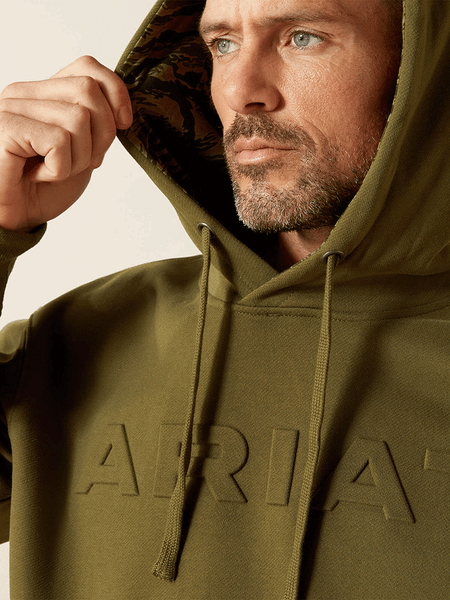 Ariat 10062501 Mens Embossed Logo Hoodie Winter Moss close up. If you need any assistance with this item or the purchase of this item please call us at five six one seven four eight eight eight zero one Monday through Saturday 10:00a.m EST to 8:00 p.m EST