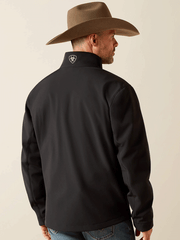 Ariat 10062578 Mens Logo Softshell Jacket Black back view. If you need any assistance with this item or the purchase of this item please call us at five six one seven four eight eight eight zero one Monday through Saturday 10:00a.m EST to 8:00 p.m EST