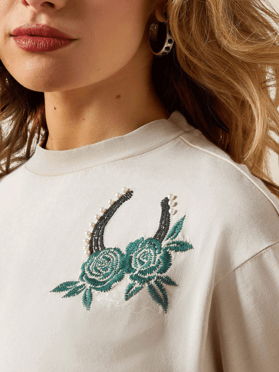 Ariat 10065976 Womens Lucky T-Shirt Washed Beige design close up. If you need any assistance with this item or the purchase of this item please call us at five six one seven four eight eight eight zero one Monday through Saturday 10:00a.m EST to 8:00 p.m EST