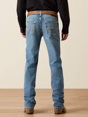 Rear view of a person wearing light blue denim jeans with a brown woven belt, black long-sleeve shirt, and brown boots against a beige studio background. If you need any assistance with this item or the purchase of this item please call us at five six one seven four eight eight eight zero one Monday through Saturday 10:00a.m EST to 8:00 p.m EST