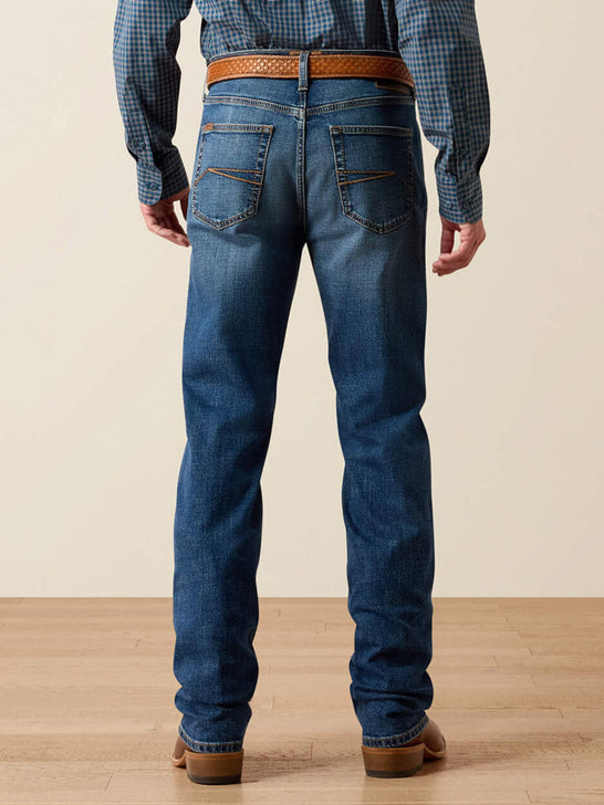 Rear view of a person wearing blue denim jeans with a brown woven belt, a blue-and-white check shirt, and brown shoes against a beige studio background. If you need any assistance with this item or the purchase of this item please call us at five six one seven four eight eight eight zero one Monday through Saturday 10:00a.m EST to 8:00 p.m EST