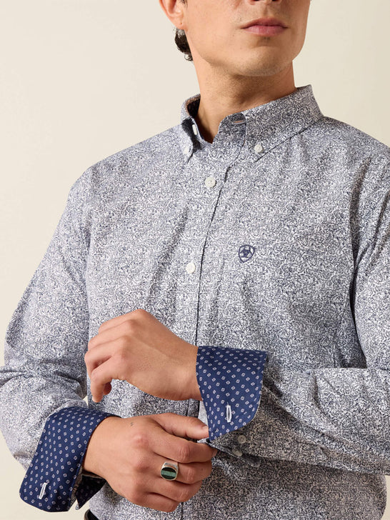 A man wearing a light gray and white micro-patterned button-down shirt with navy blue polka-dot turned-back cuffs, shown from the chest down against a light beige background. If you need any assistance with this item or the purchase of this item please call us at five six one seven four eight eight eight zero one Monday through Saturday 10:00a.m EST to 8:00 p.m EST