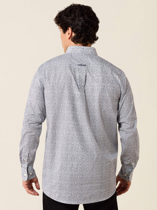 A man viewed from the back wearing a light gray long-sleeve button-up shirt with a subtle speckled pattern and a small black ARIAT logo on the upper back, set against a solid light beige background. If you need any assistance with this item or the purchase of this item please call us at five six one seven four eight eight eight zero one Monday through Saturday 10:00a.m EST to 8:00 p.m EST