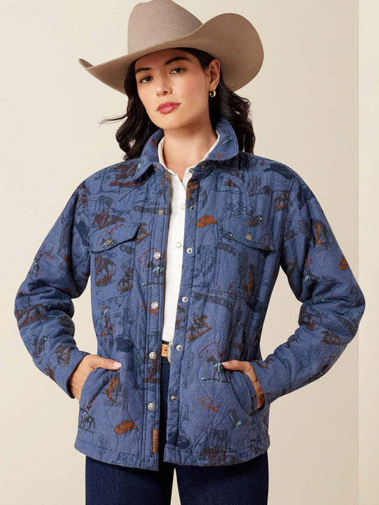 A woman wearing a blue western-style quilted jacket with a brown and tan cowboy print, a beige cowboy hat, and a white collared shirt, posing against a solid beige background. If you need any assistance with this item or the purchase of this item please call us at five six one seven four eight eight eight zero one Monday through Saturday 10:00a.m EST to 8:00 p.m EST