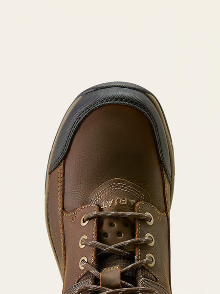 Close-up top-down view of a brown leather lace-up boot with a black rubber toe cap and metal eyelets, shown against a light off-white background. If you need any assistance with this item or the purchase of this item please call us at five six one seven four eight eight eight zero one Monday through Saturday 10:00a.m EST to 8:00 p.m EST