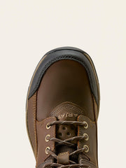 Close-up top-down view of a brown leather lace-up boot with a black rubber toe cap and metal eyelets, shown against a light off-white background. If you need any assistance with this item or the purchase of this item please call us at five six one seven four eight eight eight zero one Monday through Saturday 10:00a.m EST to 8:00 p.m EST