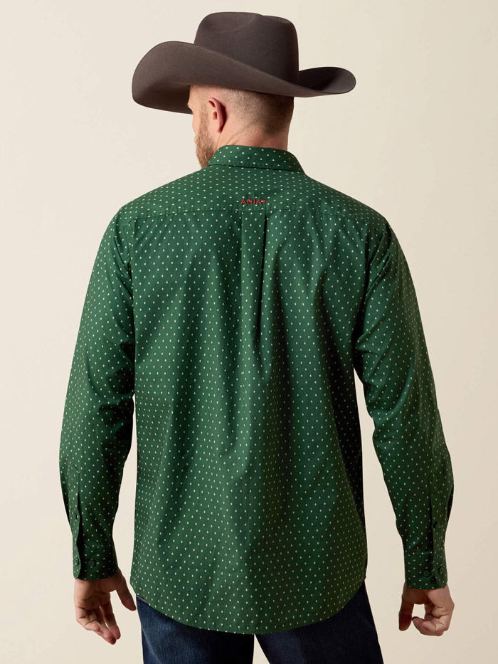 A man wearing a dark green long-sleeve button-down shirt with a small white polka dot pattern, paired with blue jeans and a dark brown cowboy hat, against a solid beige background. If you need any assistance with this item or the purchase of this item please call us at five six one seven four eight eight eight zero one Monday through Saturday 10:00a.m EST to 8:00 p.m EST