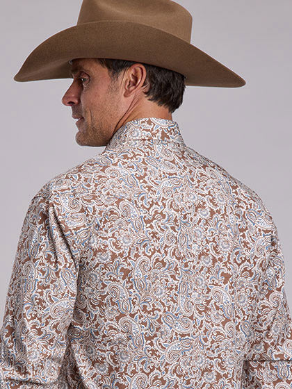 A man wearing a brown cowboy hat and a brown paisley patterned long-sleeve shirt, shown from a side-back angle against a solid light gray background. If you need any assistance with this item or the purchase of this item please call us at five six one seven four eight eight eight zero one Monday through Saturday 10:00a.m EST to 8:00 p.m EST