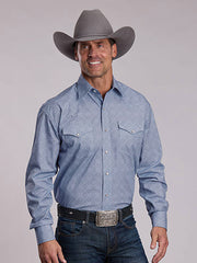 A smiling man wearing a light blue western long-sleeve button-up shirt, dark blue jeans, a black belt, and a gray cowboy hat, photographed against a plain light gray studio background. If you need any assistance with this item or the purchase of this item please call us at five six one seven four eight eight eight zero one Monday through Saturday 10:00a.m EST to 8:00 p.m EST