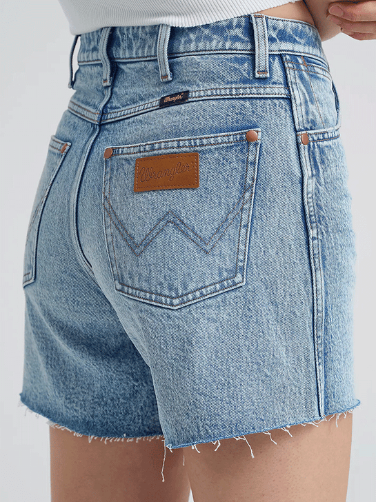 Wrangler 112373359 Womens Mid Length Cowboy Short Blissful Light Blue side close up. If you need any assistance with this item or the purchase of this item please call us at five six one seven four eight eight eight zero one Monday through Saturday 10:00a.m EST to 8:00 p.m EST