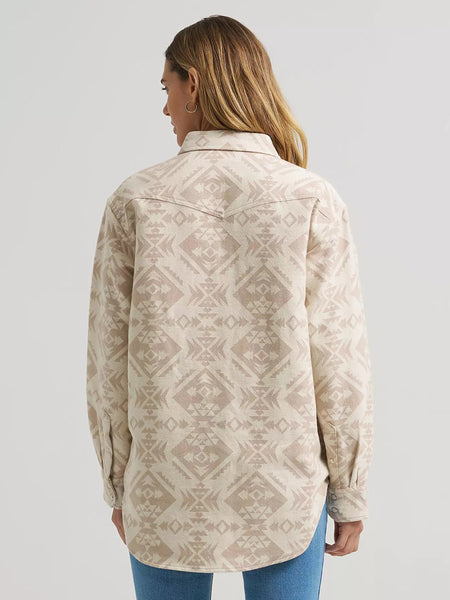 A woman shown from the back wearing a long-sleeve button-up shirt with a beige and cream geometric pattern, paired with blue jeans, against a light gray studio background. If you need any assistance with this item or the purchase of this item please call us at five six one seven four eight eight eight zero one Monday through Saturday 10:00a.m EST to 8:00 p.m EST
