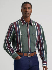 A man wearing a green western-style button-down shirt with vertical burgundy, white, and navy stripes, paired with a brown belt and dark blue jeans, against a light gray studio background. If you need any assistance with this item or the purchase of this item please call us at five six one seven four eight eight eight zero one Monday through Saturday 10:00a.m EST to 8:00 p.m EST