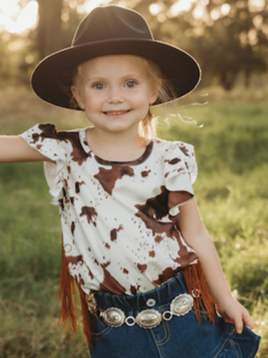 Shea Baby SBS17 Infants Cowprint With Fringe Onesie Brown And White front view on model. If you need any assistance with this item or the purchase of this item please call us at five six one seven four eight eight eight zero one Monday through Saturday 10:00a.m EST to 8:00 p.m EST