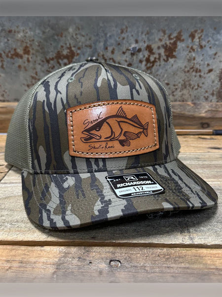 Shoot & Reel SR6 Snook Patch Curved Bill Cap Mossy Oak Bottomland side / front view. If you need any assistance with this item or the purchase of this item please call us at five six one seven four eight eight eight zero one Monday through Saturday 10:00a.m EST to 8:00 p.m EST