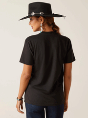 Ariat 10047839 Unisex Sendero Winking Skull T-Shirt Black back view on female model. If you need any assistance with this item or the purchase of this item please call us at five six one seven four eight eight eight zero one Monday through Saturday 10:00a.m EST to 8:00 p.m EST