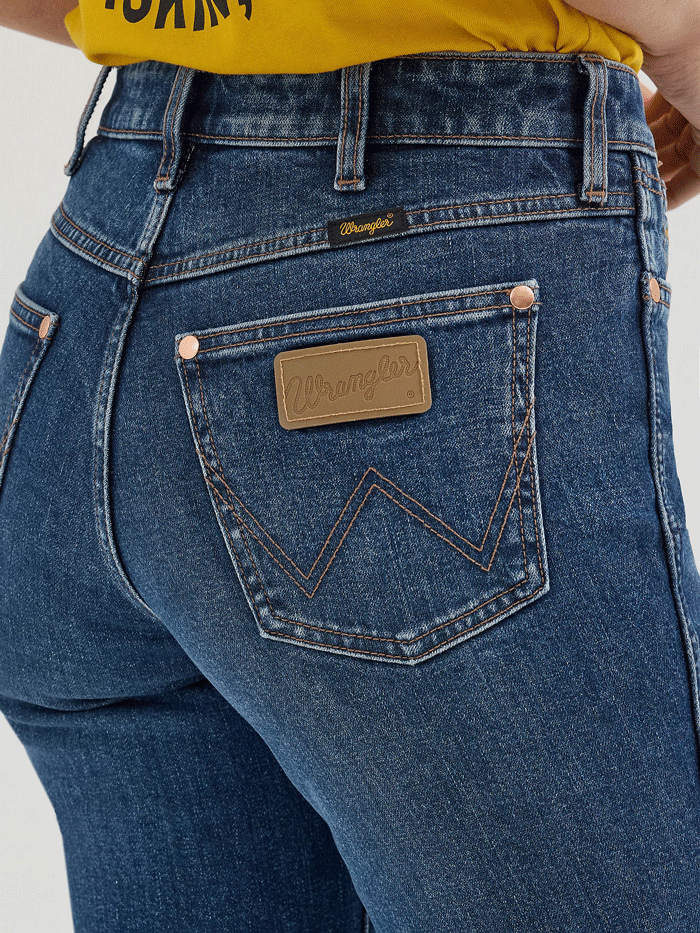 Wrangler 112360614 Womens X Lainey Wilson Boot Hugger Jeans Baskin Blue Wash front. If you need any assistance with this item or the purchase of this item please call us at five six one seven four eight eight eight zero one Monday through Saturday 10:00a.m EST to 8:00 p.m EST