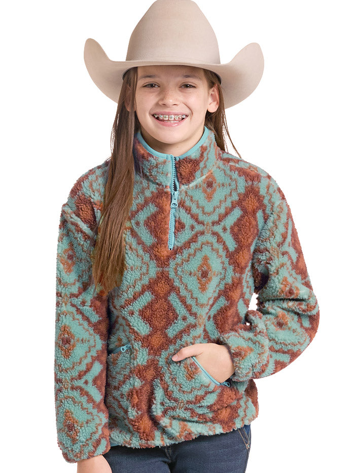 A young girl wearing a turquoise and rust-brown patterned sherpa quarter-zip fleece pullover sweater, a beige cowboy hat, and dark blue jeans, photographed against a solid white background. If you need any assistance with this item or the purchase of this item please call us at five six one seven four eight eight eight zero one Monday through Saturday 10:00a.m EST to 8:00 p.m EST