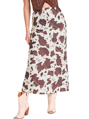 A model wearing a mid-length cow-print skirt in brown and cream, paired with light beige cowboy boots against a plain white background. If you need any assistance with this item or the purchase of this item please call us at five six one seven four eight eight eight zero one Monday through Saturday 10:00a.m EST to 8:00 p.m EST