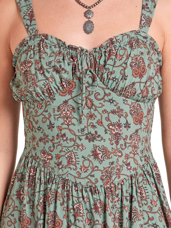 Close-up of a sleeveless dress with a ruffled sweetheart neckline and thin shoulder straps, featuring an all-over paisley and floral print in sage green, rust red, and dark brown on a white background. If you need any assistance with this item or the purchase of this item please call us at five six one seven four eight eight eight zero one Monday through Saturday 10:00a.m EST to 8:00 p.m EST