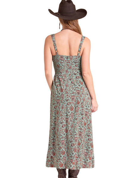 A woman shown from the back wearing a sleeveless midi dress with a green and rust floral pattern, a brown cowboy hat, and brown boots against a plain white background. If you need any assistance with this item or the purchase of this item please call us at five six one seven four eight eight eight zero one Monday through Saturday 10:00a.m EST to 8:00 p.m EST