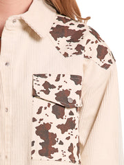 Close-up of a cream ribbed button-up shirt with brown and cream cow-print panels on the shoulders and chest pocket, worn by a model. If you need any assistance with this item or the purchase of this item please call us at five six one seven four eight eight eight zero one Monday through Saturday 10:00a.m EST to 8:00 p.m EST