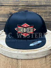 Black trucker hat with Red Dirt cowboy bowtie logo on a wooden barrel front view. If you need any assistance with this item or the purchase of this item please call us at five six one seven four eight eight eight zero one Monday through Saturday 10:00a.m EST to 8:00 p.m EST