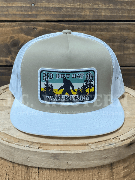 Trucker hat with wanderer logo on a wooden surface front view. 