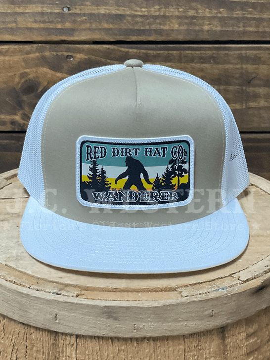Trucker hat with wanderer logo on a wooden surface front view. 