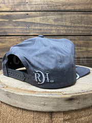 A dark gray snapback cap with a white embroidered 'RDI co.' logo on the side, displayed on a rustic wooden stool against a wooden plank background.If you need any assistance with this item or the purchase of this item please call us at five six one seven four eight eight eight zero one Monday through Saturday 10:00a.m EST to 8:00 p.m EST