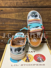 A pair of Ariat Lil' Stompers western-style sneakers with buffalo prints, turquoise laces, and orange accents, displayed on top of their branded box against a rustic wooden background. If you need any assistance with this item or the purchase of this item please call us at five six one seven four eight eight eight zero one Monday through Saturday 10:00a.m EST to 8:00 p.m EST