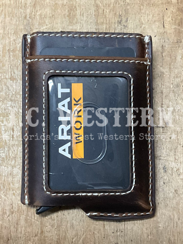 A dark brown leather wallet with white contrast stitching and a metal brand plate reading 'ARIAT WORK' on the front, shown against a plain white background. If you need any assistance with this item or the purchase of this item please call us at five six one seven four eight eight eight zero one Monday through Saturday 10:00a.m EST to 8:00 p.m EST