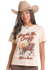 A woman wearing a beige cowboy hat and a cream-colored graphic t-shirt with 'Buckle Up Country' and 'Life's a Rider' printed on the front, set against a plain white background. If you need any assistance with this item or the purchase of this item please call us at five six one seven four eight eight eight zero one Monday through Saturday 10:00a.m EST to 8:00 p.m EST