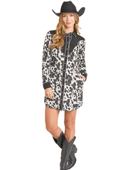 Woman wearing a cow print dress with black accents and a cowboy hat on a white background front view. If you need any assistance with this item or the purchase of this item please call us at five six one seven four eight eight eight zero one Monday through Saturday 10:00a.m EST to 8:00 p.m EST