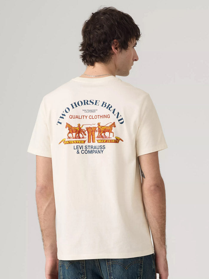 A man wearing a cream-colored Levi's t-shirt, viewed from the back. The shirt features a large graphic print with the text 'TWO HORSE BRAND' and 'LEVI STRAUSS & COMPANY' in blue, along with an orange illustration of a carriage and horses. If you need any assistance with this item or the purchase of this item please call us at five six one seven four eight eight eight zero one Monday through Saturday 10:00a.m EST to 8:00 p.m EST