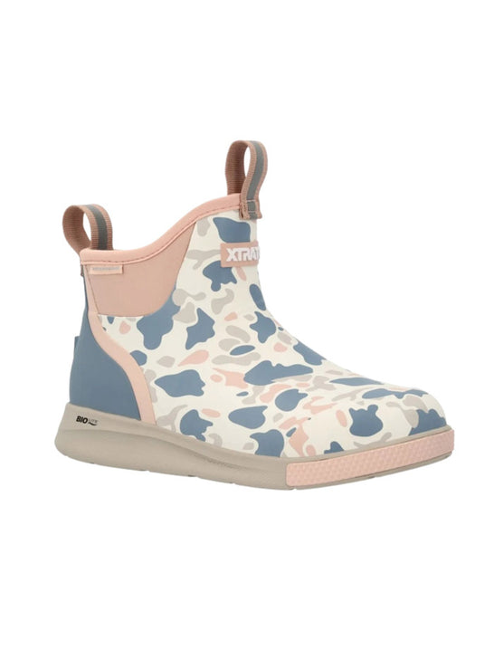 A single ankle-height slip-on boot with a pastel camouflage pattern in blue, pink, and cream, featuring a light pink collar, pull tabs, and sole, and a blue heel accent. If you need any assistance with this item or the purchase of this item please call us at five six one seven four eight eight eight zero one Monday through Saturday 10:00a.m EST to 8:00 p.m EST